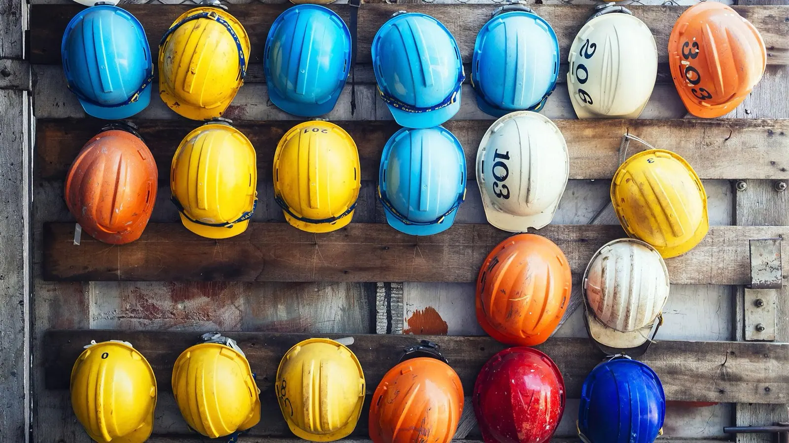 Veiligheidshelmen aan een houten wand